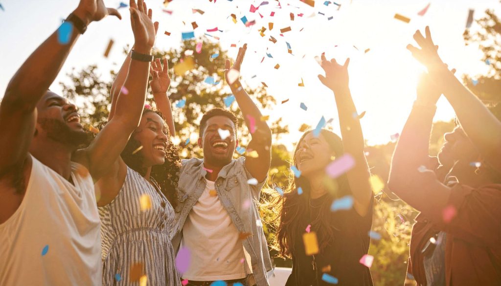 party guests cheering as a birthday confetti cannon bursts